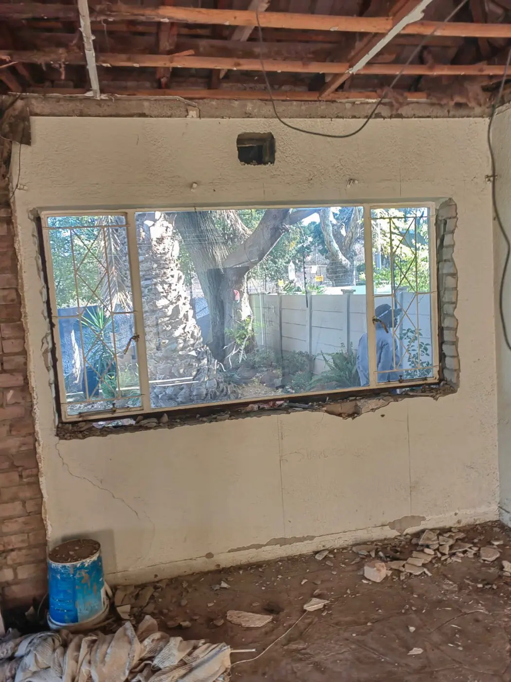 An old steel-framed window in a cracked plaster wall
