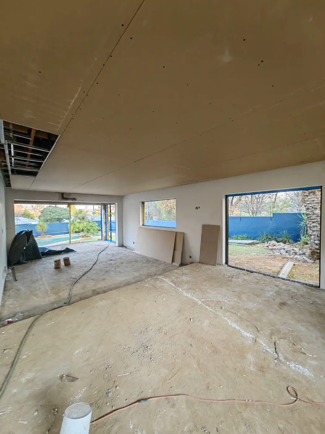 The new open-plan living area with fresh ceiling boards and bare floor