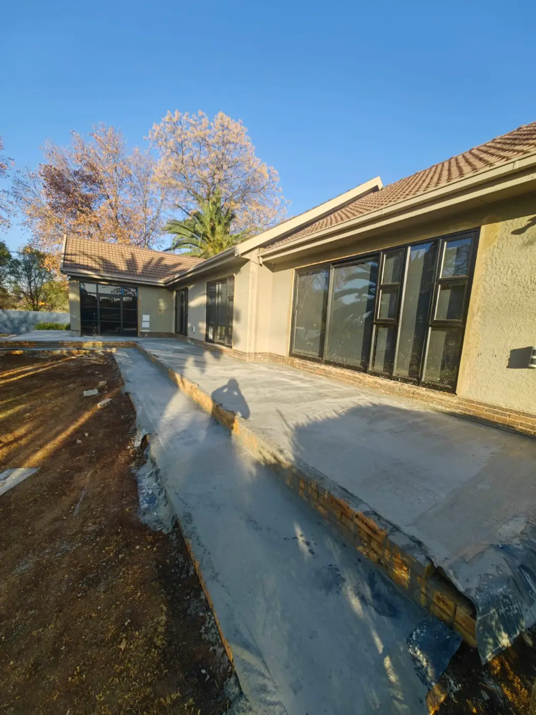 The new concrete patio slab poured along the back of the house