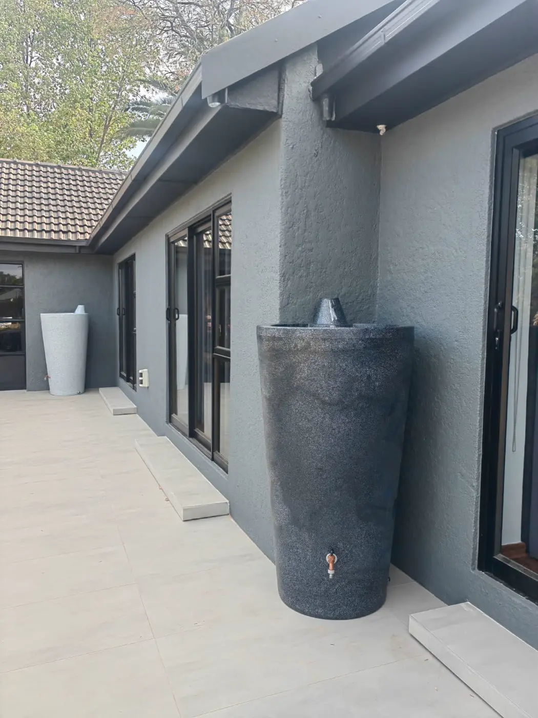 A side patio with a dark planter against the new grey walls