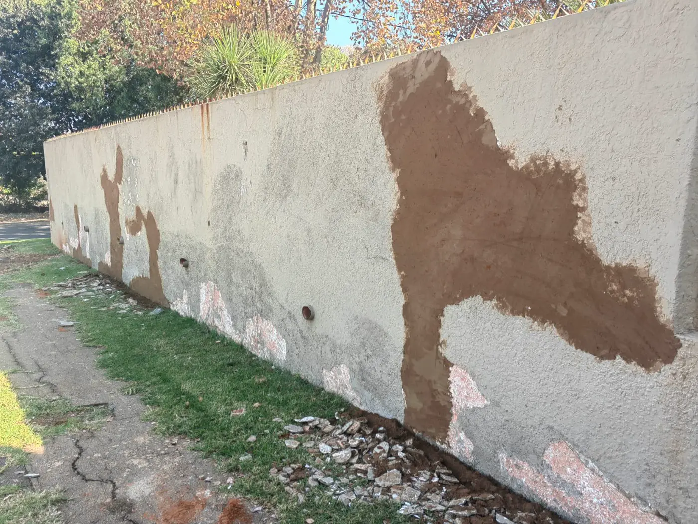 Fresh plaster patches along the long boundary wall