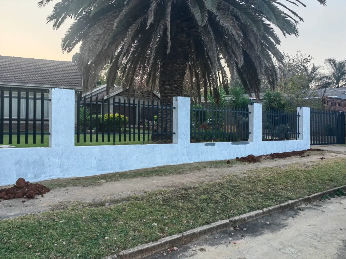 The wall rendered white with the new palisade panels fitted