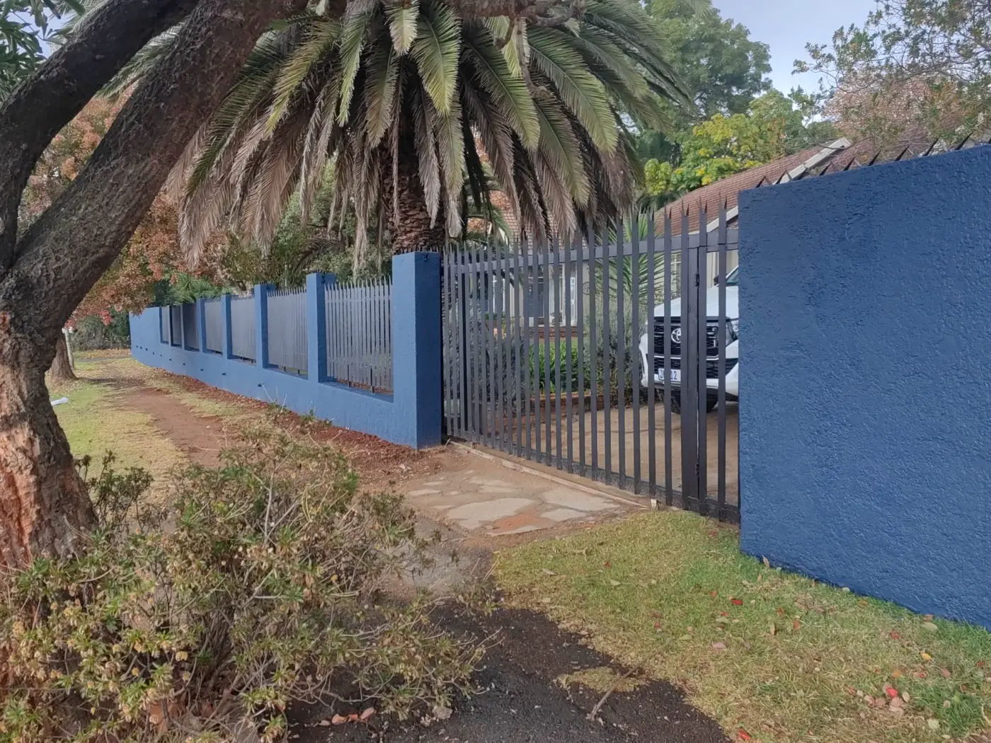 The finished wall and black steel gate from the pavement
